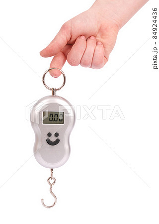 Hand holding a small portable electronic scale Hand holding a small portable electronic scale 84924436