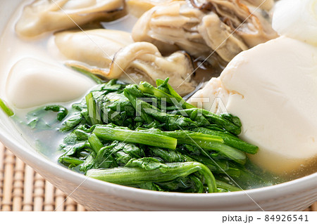 カキと豆腐の汁物に入れられた春菊のアップ。 84926541