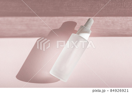 Skin moisturizing serum on pink backdrop with shadow. Beauty skincare essence mockup tincture flat lay, wellness packaging. Hyaluronic acid oil mock up. Lliquid product in glass bottle Skin moisturizing serum on pink backdrop with shadow. Beauty skincare essence mockup tincture flat lay, wellness packaging. Hyaluronic acid oil mock up. Lliquid product in glass bottle 84926921