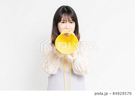 白い背景の前に立って応援するレースのブラウスを着た若い女性 白い背景の前に立って応援するレースのブラウスを着た若い女性 84929570