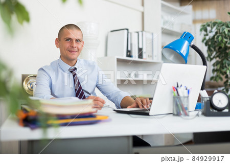 Male office worker sitting in his workplace 84929917