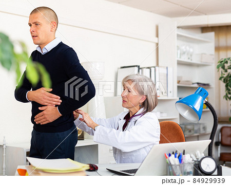 Senior woman nephrologist examining patient complaining of kidneys pain 84929939