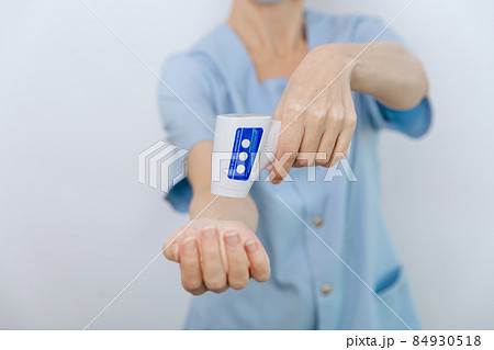 Temperature measurement gun in doctor hands. Close-up shot of doctor wearing protective surgical mask ready to use infrared isometric thermometer gun to check body temperature for virus symptoms. Temperature measurement gun in doctor hands. Close-up shot of doctor wearing protective surgical mask ready to use infrared isometric thermometer gun to check body temperature for virus symptoms. 84930518