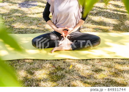 休日に公園でヨガをする女性 休日に公園でヨガをする女性 84931744
