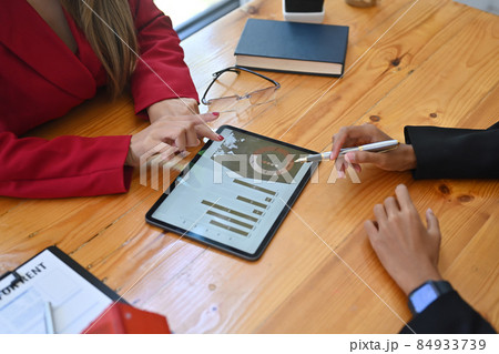 Two business people analyzing financial graph on digital tablet together. Two business people analyzing financial graph on digital tablet together. 84933739