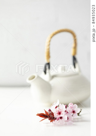 White ceramic teapot and spring flowers on white table, selective focus White ceramic teapot and spring flowers on white table, selective focus 84935023