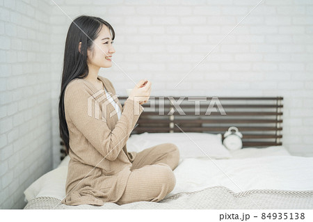 ヨーグルトを食べる女性(ベッドルーム) ヨーグルトを食べる女性(ベッドルーム) 84935138