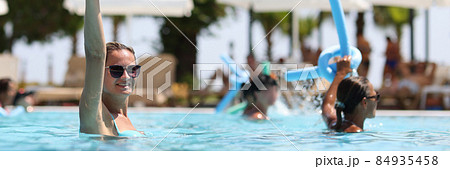 Young women during water aerobics classes in hotel pool closeup Young women during water aerobics classes in hotel pool closeup 84935458
