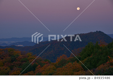 夜明け前の紅葉の尾根と西の空低くに見える満月　大小山南側の小ピークから大坊山方面を見る 84935486