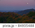 夜明け前の紅葉の尾根と西の空低くに見える満月　大小山南側の小ピークから大坊山方面を見る 84935488