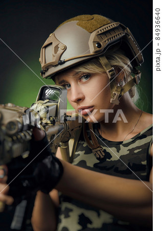 a soldier girl poses with an automatic rifle a soldier girl poses with an automatic rifle 84936640