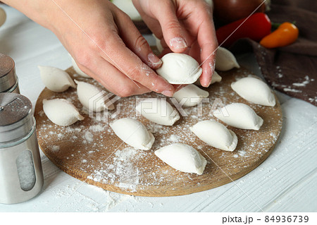 Concept of cooking vareniki or pierogi on white wooden table Concept of cooking vareniki or pierogi on white wooden table 84936739