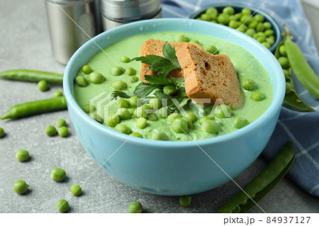 Concept of tasty eating with pea soup on gray textured table Concept of tasty eating with pea soup on gray textured table 84937127