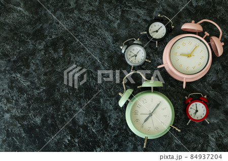 Multicolor alarm clocks on black smokey table Multicolor alarm clocks on black smokey table 84937204