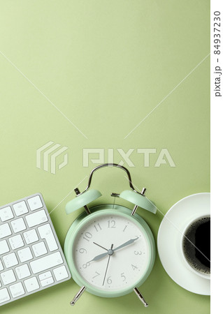 Workplace concept with alarm clock on green background 84937230
