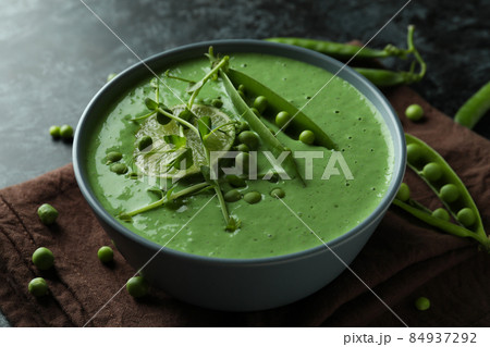 Concept of tasty eating with pea soup on black smokey table 84937292