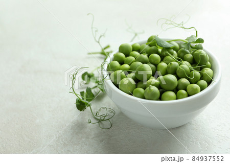 Bowl with pea seeds on white textured background Bowl with pea seeds on white textured background 84937552