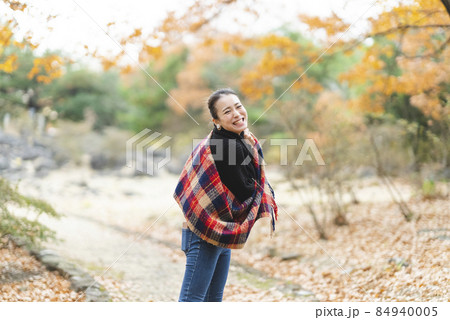 紅葉の公園で遊ぶ女性 84940005
