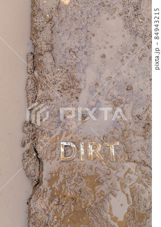 the word mud imprinted in wet dirt road surface - close-up with selective focus the word mud imprinted in wet dirt road surface - close-up with selective focus 84943215