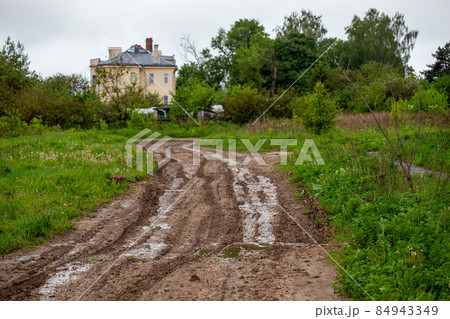 dirty clay mud road with puddles and tire tracks - closeup with selective focus and linear perspective dirty clay mud road with puddles and tire tracks - closeup with selective focus and linear perspective 84943349