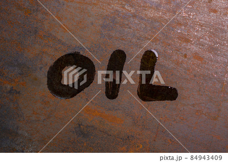 handwritten word oil on rusted sheet metal surface - close-up with selective focus 84943409
