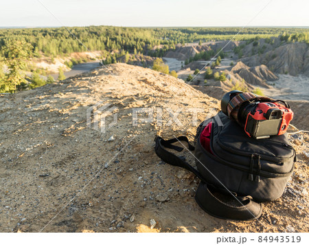 professional camera and photo backpack on top of the hill at summer daytime 84943519