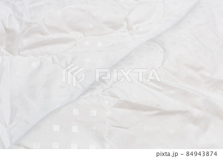 White fabric blanket close-up backdrop with selective focus and background blur 84943874