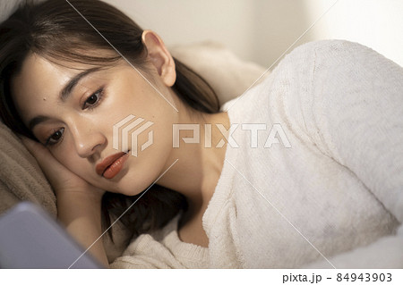 ベッドでスマホを見る女性 ベッドでスマホを見る女性 84943903