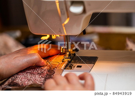 a close-up view of sewing process, hand of old woman using sewing machine, selective focus technique a close-up view of sewing process, hand of old woman using sewing machine, selective focus technique 84943919