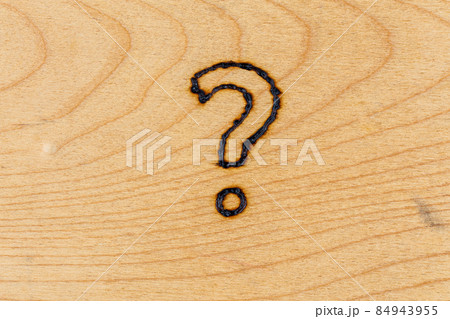 question mark drawn with handheld woodburner on flat wooden surface question mark drawn with handheld woodburner on flat wooden surface 84943955