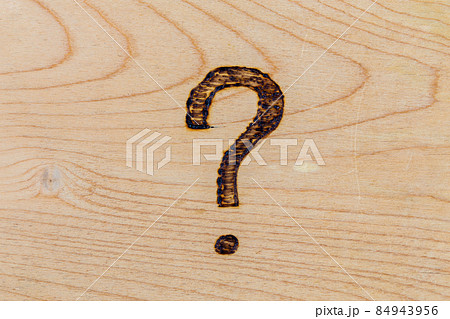 question mark drawn with handheld woodburner on bright flat wooden surface question mark drawn with handheld woodburner on bright flat wooden surface 84943956