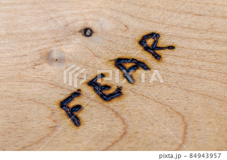 the word fear burned by hand on flat wooden board in diagonal composition and selective focus the word fear burned by hand on flat wooden board in diagonal composition and selective focus 84943957