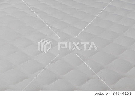 Soft white mattress close-up background with selective focus. 84944151