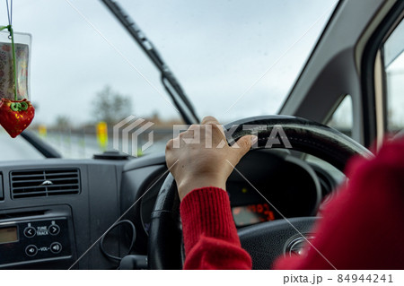 赤い服を着た女性が運転している軽自動車の運転席 84944241