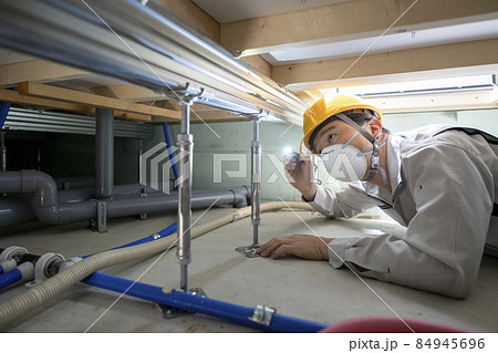 住宅の床下を点検する作業服の男性 84945696