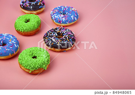 Delicious multicolored donuts on a pink background. 84948065