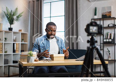 African man recording video while unboxing present 84948855