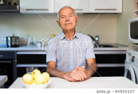 Portrait of old man in kitchen 84950107