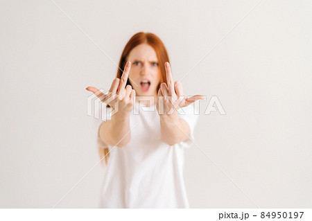 Portrait of rage annoyed young woman showing middle fingers on both arms, gesture of disrespect and hate, rude fuck off expression. Portrait of rage annoyed young woman showing middle fingers on both arms, gesture of disrespect and hate, rude fuck off expression. 84950197