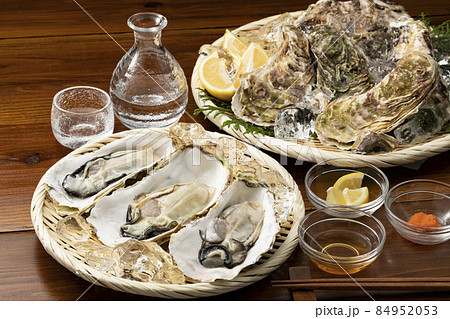 ざるに乗せた殻付きの生牡蠣と日本酒 84952053