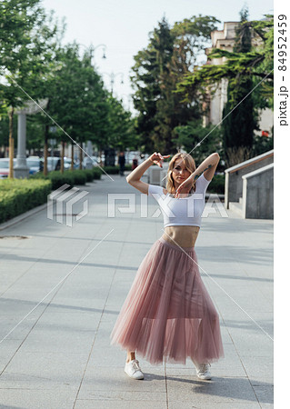 beautiful woman dancing to music on the street of the city beautiful woman dancing to music on the street of the city 84952459