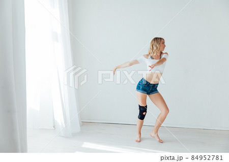 beautiful slender woman dancing to music in a white hall 84952781