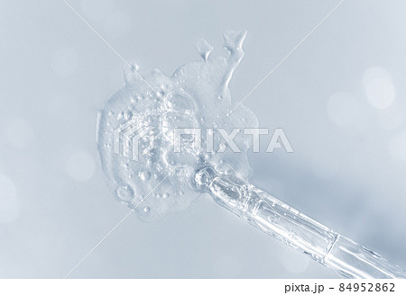 Pipette with fluid hyaluronic acid on gray background. Cosmetics and healthcare concept closeup. Dose of serum or retinol with air bubbles. Flat lay. Luxury gel or beauty product presentation in macro Pipette with fluid hyaluronic acid on gray background. Cosmetics and healthcare concept closeup. Dose of serum or retinol with air bubbles. Flat lay. Luxury gel or beauty product presentation in macro 84952862