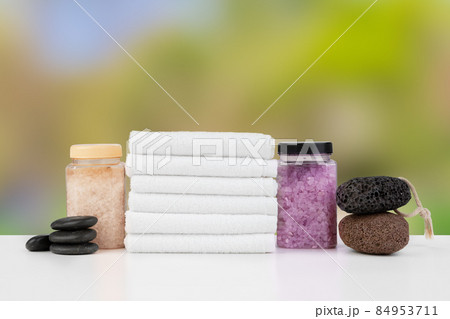Various spa beauty threatment products and towels against blurred background Various spa beauty threatment products and towels against blurred background 84953711