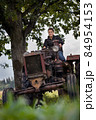 Young girl, old tractor and old oak 84954153