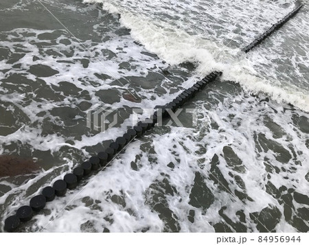 Breaking waves on a wooden breakwater on the Baltic Sea coast. Breaking waves on a wooden breakwater on the Baltic Sea coast. 84956944