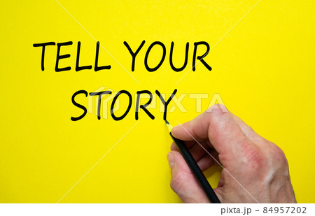 Hand writing 'tell your story', isolated on yellow background. Business concept. 84957202