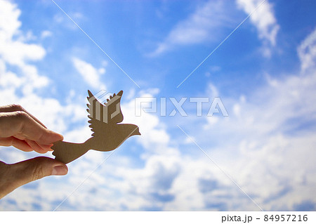Man hand holding wooden bird on cloud sky background. The development of the imagination, copy space. Man hand holding wooden bird on cloud sky background. The development of the imagination, copy space. 84957216