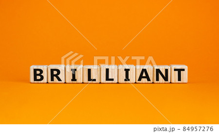 Brilliant symbol. The concept word Brilliant on wooden cubes. Beautiful orange table, orange background. Business and brilliant concept. Copy space. 84957276