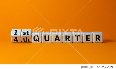 From 4th to 1st quater symbol. Turned wooden cubes and changed words '4th quater' to '1st quater'. Beautiful orange table, orange background. Business, happy 1st quater concept, copy space. 84957279
